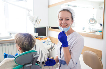 Portrait of female dentist. She standing in her dentist office.