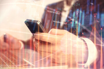 Multi exposure of man's hands holding and using a digital phone and forex graph drawing. Financial market concept.