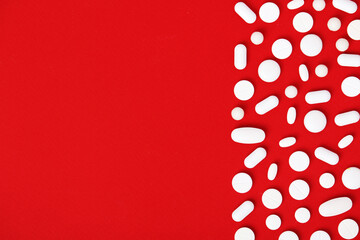 Bright red background with white medicine tablets