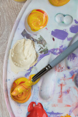 Artist's palette, top view. Mixing paints, brush. Texture, background