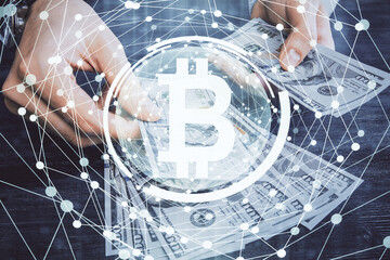 Multi exposure of blockchain theme drawing hologram and USA dollars bills and man hands. Business concept.
