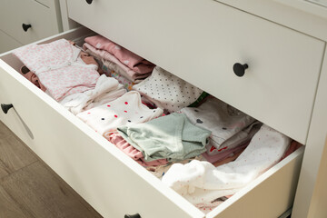 Cute newborn clothes in drawer