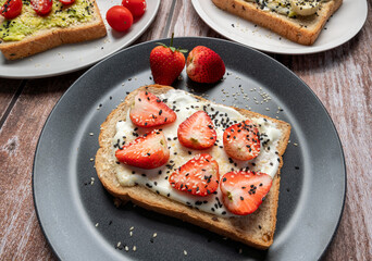 Healthy breakfast toasts with strawberry, Yoghurt with whole grain sandwich bread on black dish. Concept of healthy eating, dieting, vegan vegetarian food
