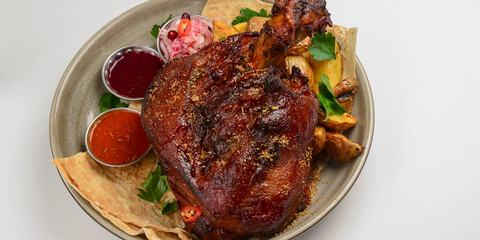 A top steak grilled on a barbecue, served on a plate with two different kinds of sauce over white background.