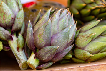 close up of  raw artichokes on a wooden table, gluten free, vegan