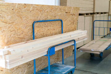 Trolley in a hardware store with building materials. Warehouse large storage. Trolley in a hardware store loaded with boards