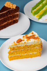 Piece of different kinds of cake with icing on top. Over blue background. Sweet dessert for tea or coffee time.