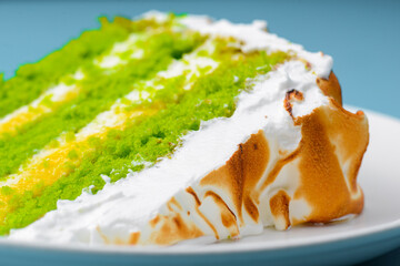 One piece of green tea cake over blue background. Sweet dessert for tea or coffee time.