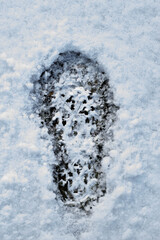 Footprint of a man's boot in the snow 