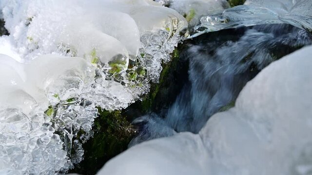 Eisbach mit gefrohrenem Wasser und Moos