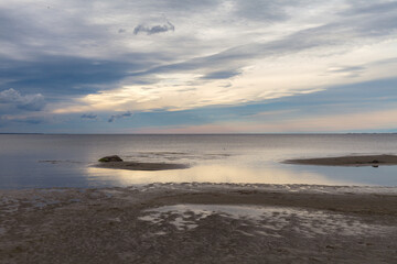 Dense clouds in the sky over calm sea with sunlight reflection. Minimalistic photo