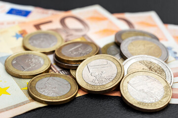 Heap of euro coins on euro bills. Close up.