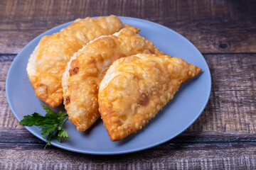 Chebureks with meat. Deep-fried flat pie. A traditional dish. Close-up.