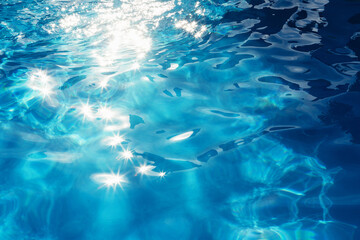 Fototapeta na wymiar Background of the sun reflections in the surface of the blue water of a pool during summer