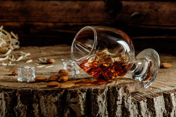 Whiskey with ice or brandy or rum in glass on rustic background. Whiskey with ice in a glass....