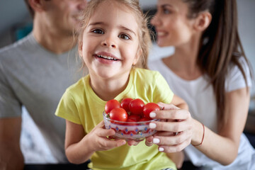 Cheerful couple wiith daughter having breakfast together