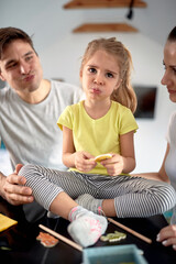 Happy parents playing together with their daughter; Family time concept