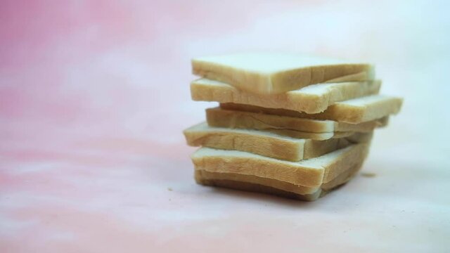 A bread slice falling on pile bread in slow motion