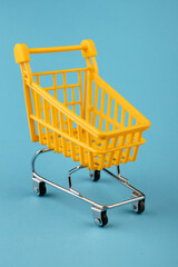 Empty yellow shopping basket on a blue background. Shopping and crisis concept