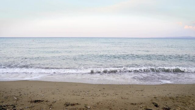 Leerer Strand in Thurio in Kalabrien, Italien. Ein kalter, welliger Tag. Am Ende des Bildes fliegt ein Vogel von rechts nach links.