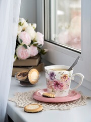 A cup of black tea with lemon by the window
