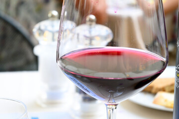 Vino rosso in primo piano nel calice da vino per degustazione servito al tavolo