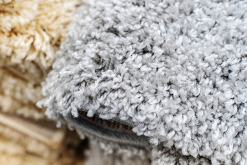 A fragment of a synthetic carpet with a large pile. Floor covering made of pvc threads. Close-up