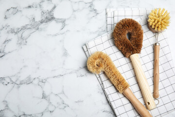 Cleaning brushes on white marble table, flat lay with space for text. Dish washing supplies
