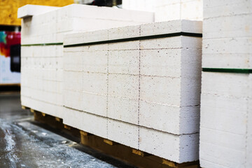Foam concrete blocks. Bricks in a large package at a warehouse of a building materials store. Selective focus. Copy space
