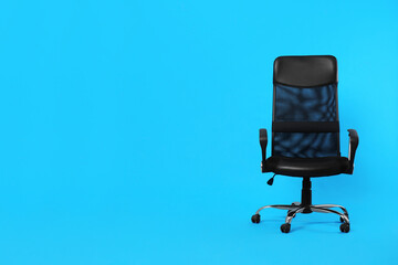 Comfortable office chair on light blue background, space for text