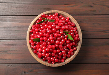 Tasty ripe cranberries on brown wooden table, top view