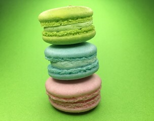 Colorful macaroni cookies, macaroni cake or macaroni cookies on green background. Space for text