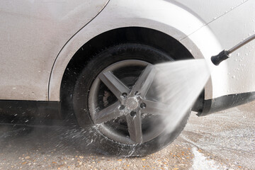 cleaning the vehicle with pressurized water hose