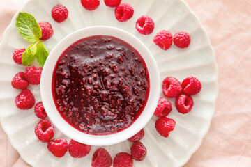 Bowl with sweet raspberry jam on table