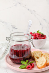 Composition with sweet raspberry jam on light background