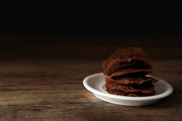 Saucer with used tea bags on wooden table. Space for text