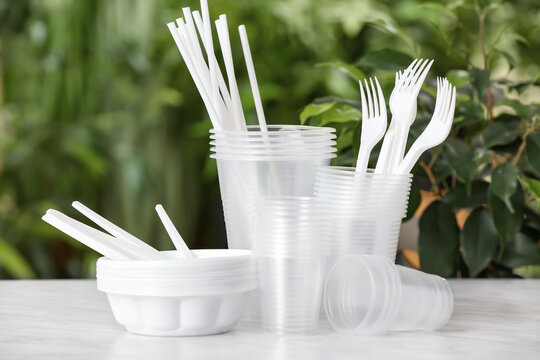 Plastic tableware on table against blurred background
