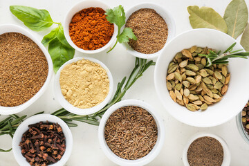 Bowls with different spices on light background