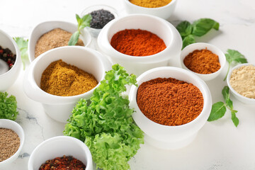 Bowls with different spices on light background