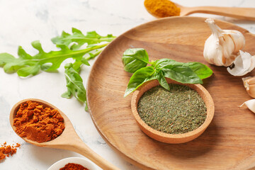 Bowl and spoons with different spices on light background, closeup