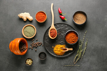 Bowls with different spices on dark background