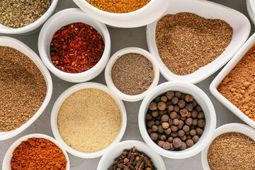 Bowls with different spices on light background, closeup