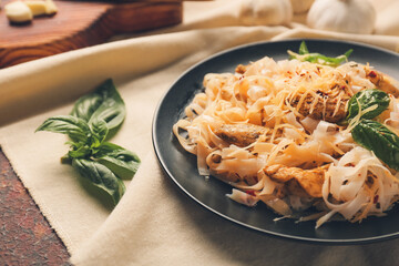 Plate with tasty noodles on grunge background, closeup