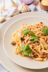 Plate with tasty noodles and chicken on table, closeup