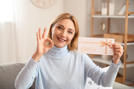 Mature Woman With Gift Card Showing OK At Home