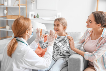 Obraz na płótnie Canvas Pediatrician examining little girl at home