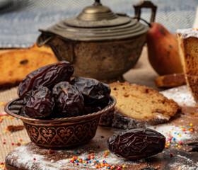 A cup of hot tea with dates on wooden background