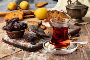 A cup of hot tea with dates on wooden background