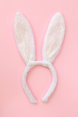 Fluffy bunny ears isolated on pink background, top view, flat lay.