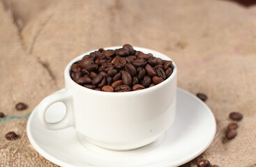variety of roasted arabica and robusta coffee beans from Indonesia, pouring from a cup